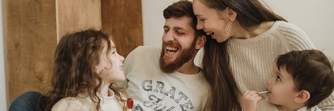 Happy family enjoying quality time with their children indoors, sharing laughter and joy.