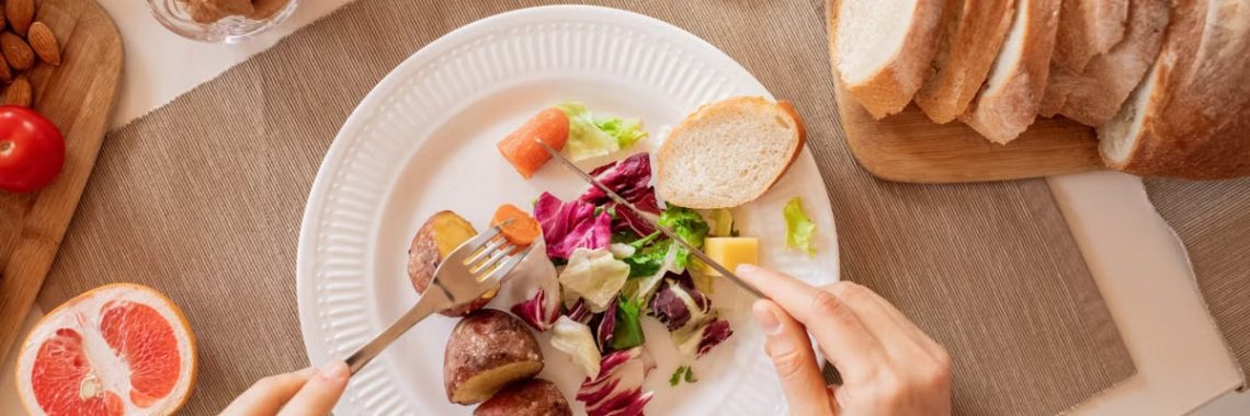Top view of a nutritious breakfast setup with salad, bread, and fresh juice, perfect for a healthy start.